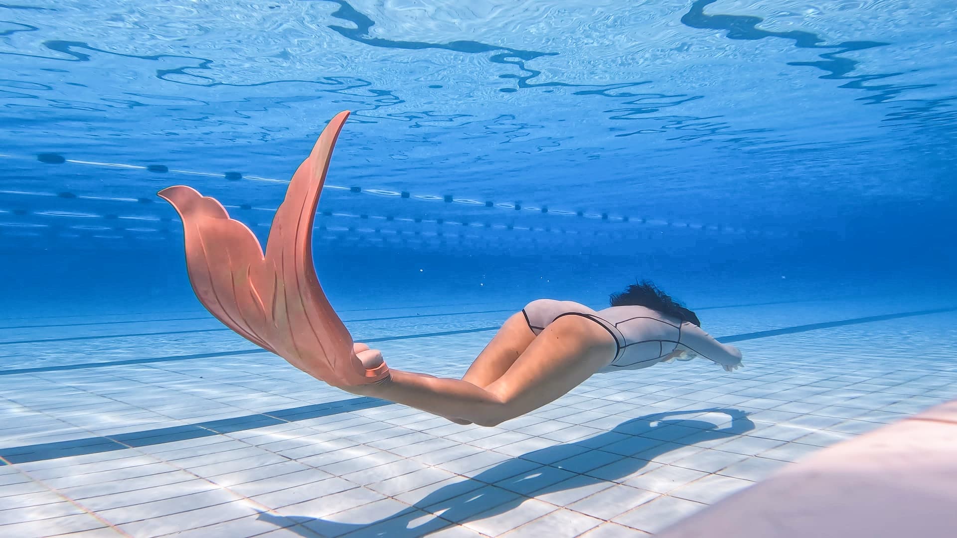Student gliding with a monofin in the pool