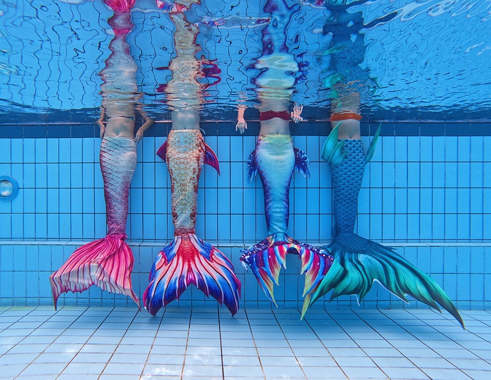 Four colourful mermaid tails side by side